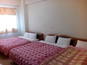 a bedroom with two beds and a window at Sky Water in Puli