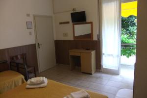 リミニにあるAlbergo Villalmaのデスクと窓付きの部屋が備わる客室です。