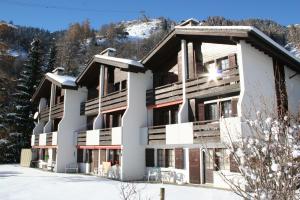 a large building with snow on the ground at Ausblick in Blatten bei Naters