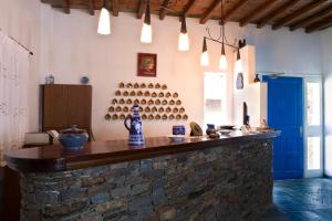 a bar in a room with a brick wall at Alexandros Hotel in Platis Gialos