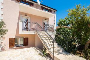 una casa con una escalera delante de ella en Apartments Judita, en Supetar