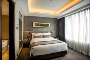 a hotel room with a bed and a bath tub at Best Western Plus Maple Leaf in Dhaka