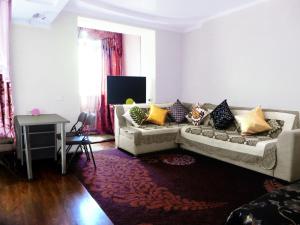 sala de estar con sofá y almohadas en Best-Bishkek City Apartment, en Bishkek