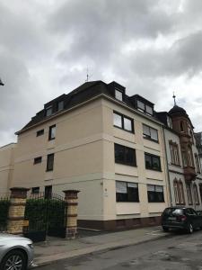 a large white building with a black roof at Domus Merian XII in Trier