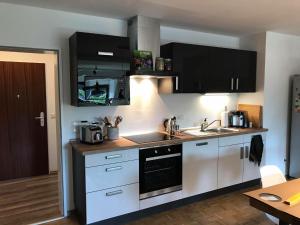 a kitchen with white appliances and black cabinets at Domus Merian XII in Trier