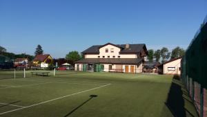 a tennis court with a house in the background at Sportpenzion Pohoda in Pilsen