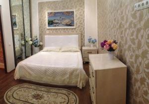エッセントゥキにあるАпартаменты на улице Пятигорская 24, 2 этажのベッドルーム1室(ベッド1台、花瓶付きのテーブル付)