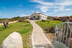 un camino de piedra que conduce a una casa con una puerta en Appartamenti Sant'Anna en Budoni