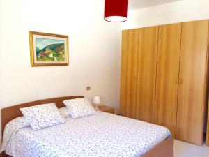 カステルサルドにあるApartament Lucìa 150mt from beachのベッドルーム1室(ベッド1台付)、木製キャビネットが備わります。