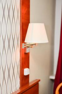 a lamp sitting on a table next to a door at Astra Hotel in Klaipėda