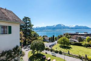 モントルーにあるSwiss Historic Hotel Massonの湖と山の景色を望む建物