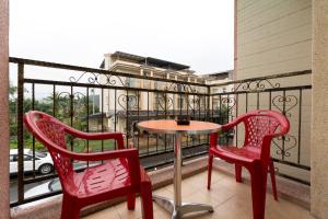 two red chairs and a table on a balcony at Papa and Mama B&B in Dayin