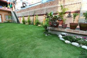 a backyard with two dogs walking in the grass at Aarya Chaitya Inn in Kathmandu