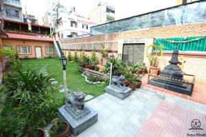 a courtyard with statues and plants in a building at Aarya Chaitya Inn in Kathmandu
