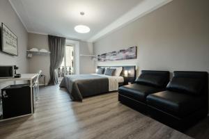 a bedroom with a bed and a couch and a desk at Residenza Navona Verona in Verona