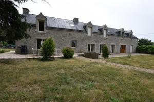 una vieja casa de piedra con un patio delante en Domaine Uraveni, en Theix