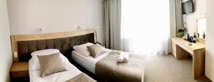 a hotel room with two beds and a mirror at Hotel *** NAT Jarosławiec in Jarosławiec