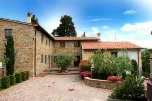 una casa de piedra con un patio frente a ella en Residence il Poggiolino, en Montecarelli