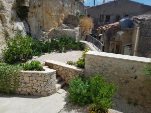 einen Steinweg, der zu einem Gebäude mit einer Steinmauer führt in der Unterkunft Casa Ronco Scalzo in Palazzolo Acreide