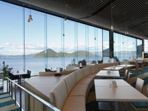 a dining room filled with tables and chairs at The Lake View Toya Nonokaze Resort in Lake Toya