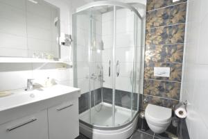a bathroom with a shower and a toilet and a sink at Artemis Selcuk Suites in Selcuk