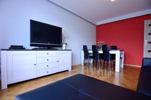 ソポトにあるVictus Apartamenty, Apartament Jantarのリビングルーム(テレビ付)、白いドレッサー(椅子付)