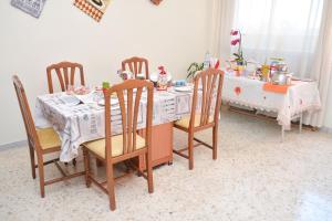 uma mesa de jantar com 4 cadeiras e uma mesa com em Lian Room B&B em Caserta mais 46 fotografias