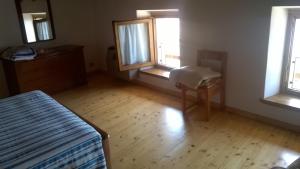 una stanza vuota con un letto e due finestre di Casa Rita a San Zeno di Montagna