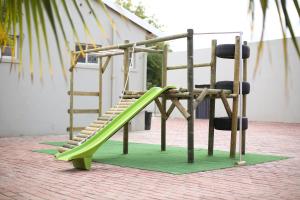 a playground with a green slide and a chair at The Hamlet Country Lodge in Ceres