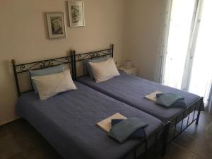 a bedroom with a bed with blue sheets and pillows at Serifos Palace in Livadakia