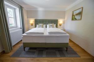 a large bed in a room with a large window at Schlosstaverne in Braunau am Inn