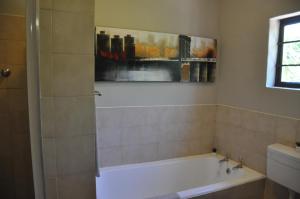 a bathroom with a bath tub and a painting on the wall at Sedgefield Island Villa in Sedgefield