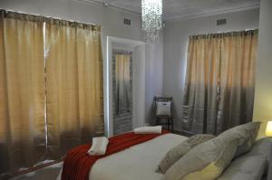 a bedroom with a large bed and a chandelier at Sedgefield Island Villa in Sedgefield