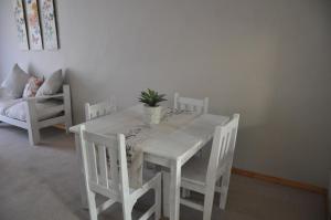 a white table and chairs with a potted plant on it at Sedgefield Island Villa in Sedgefield