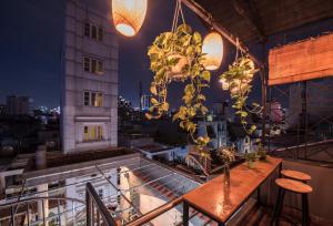 a balcony with a table and chairs and lights at The Like Hostel & Cafe in Ho Chi Minh City