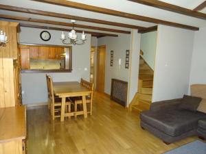 eine Küche und ein Esszimmer mit Tisch und Sofa in der Unterkunft Duplex Usuaia con Jacuzzi in Lesaka