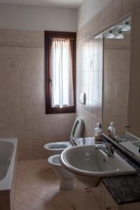 a bathroom with two sinks and a toilet and a mirror at Le Ortensie in Dolceacqua