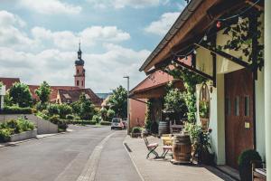 una calle con un edificio y una iglesia con una torre de reloj en Weingut Leininger Ferienwohnungen, en Eibelstadt