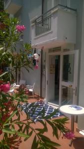 une terrasse avec une table et des fleurs devant un bâtiment dans l'établissement Albergo Maria Gabriella, à Rimini