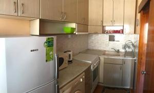 a kitchen with a white refrigerator and a sink at Apartment Geni in Pomorie