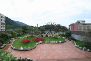 a garden with flowers and plants in a city at Green Life Spa Hot Spring Hotel in Jiaoxi