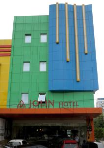 a hotel with a sign on the front of it at Hotel Jolin in Makassar