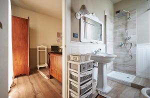 La salle de bains blanche est pourvue d'un lavabo et d'un miroir. dans l'établissement Ronchettino B&B Rozzano, à Rozzano