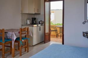 Dimitra Apartments في سيتيا: مطبخ وغرفة طعام مع طاولة وكراسي