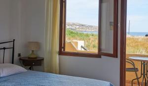 a bedroom with a window with a view of the ocean at Dimitra Apartments in Sitia