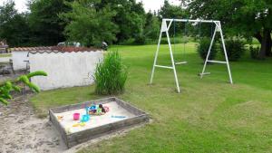 a play set in a yard with a swing at Lyngbjerggaard Ferieboliger - B&B in Fjerritslev