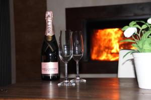 a bottle of wine and two wine glasses on a table at B&B Lo Matsòn in Chambave +150 photos