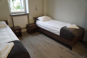 1 dormitorio con 2 camas y 2 mesitas de noche en SmartMotel en Pultusk