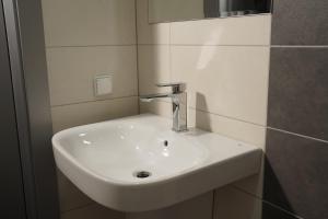 lavabo blanco en el baño con espejo en SmartMotel en Pultusk
