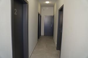 pasillo con 2 puertas negras y suelo de baldosa en SmartMotel en Pultusk
